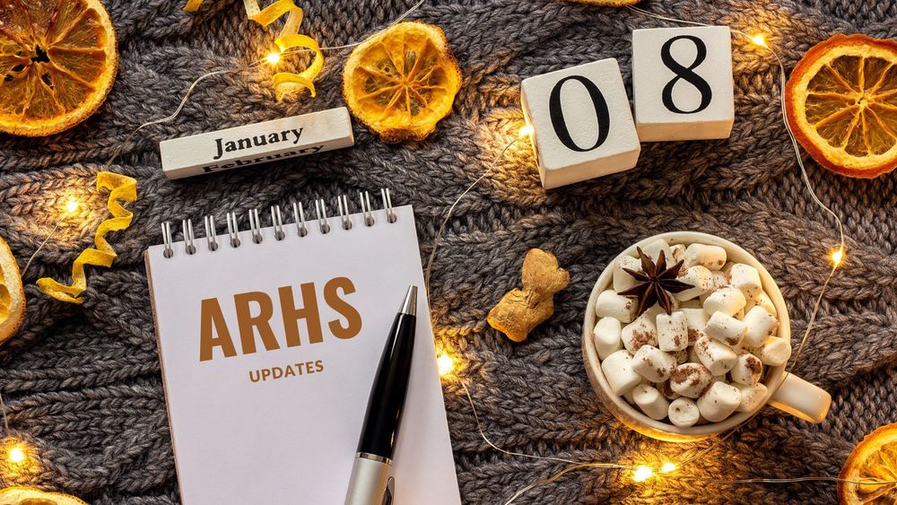 image of a notepad, pen, hot chocolate with marshmallows, and dried oranges with text of ARHS updates, January 8
